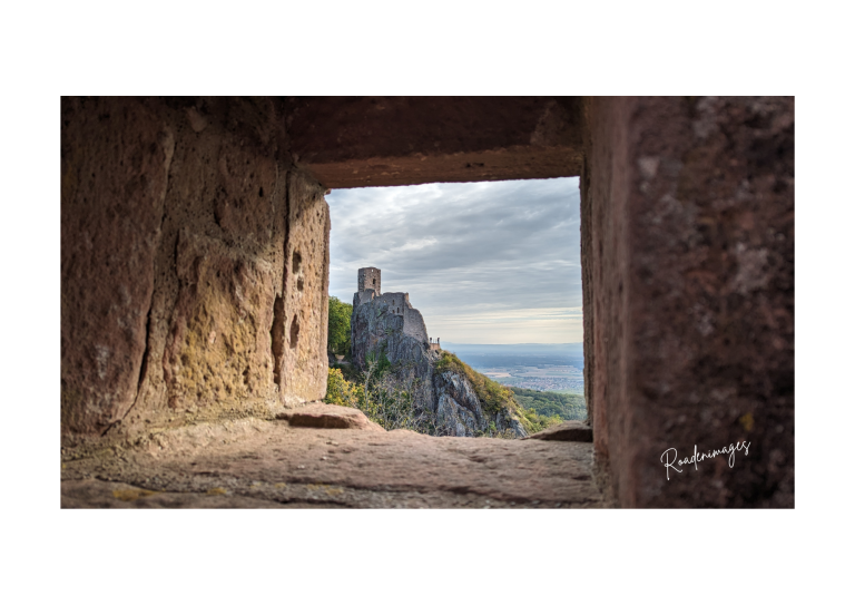 Fenêtre sur ruine Vue d'une ruine avec un paysage montagneux et une vallée au loin.