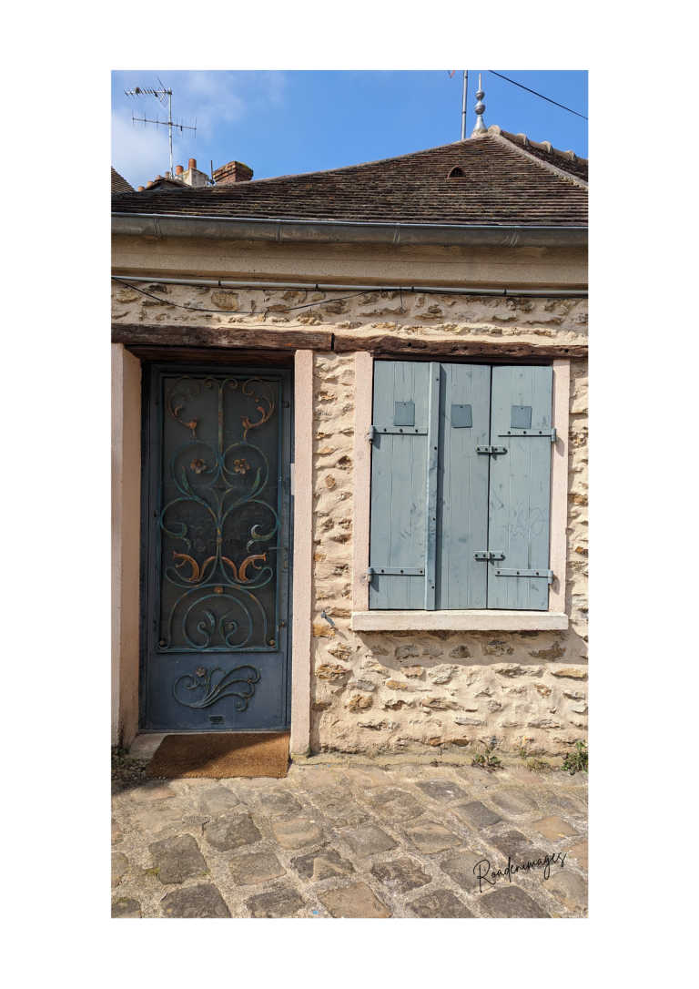 Nuance de bleu Porte en bois bleue ornée, avec fenêtres à volets bleus sur un bâtiment en pierre.